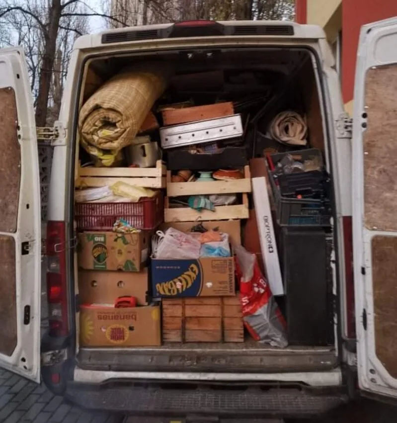 Zadní část vyklízecího vozu plného beden a nábytku - vyklízení domů a nemovitostí.